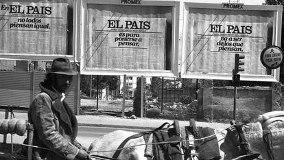 Un hombre pasa por delante de varios carteles de publicidad de EL PAÍS, en 1976.