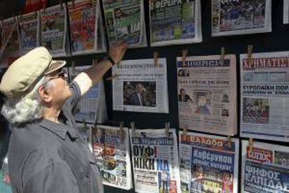Un hombre repasa titulares de distintos periódicos en Atenas, Grecia. EFE/Archivo