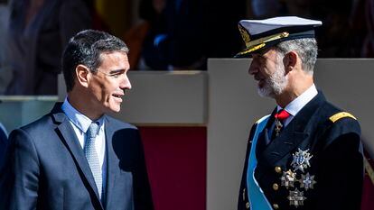 El rey Felipe conversa con el presidente del Gobierno, Pedro Sánchez, al término del desfile del Día de la Fiesta Nacional.