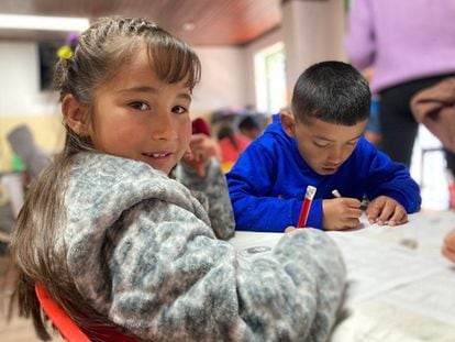 Evelyn Guerra resuelve una sopa de letras, junto a Jeremy, en el centro Amar para niños trabajadores del barrio Candelaria, en Bogotá.