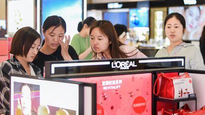 Turistas compran productos de L'Oreal en un duty free de la provincia china de Hainan.