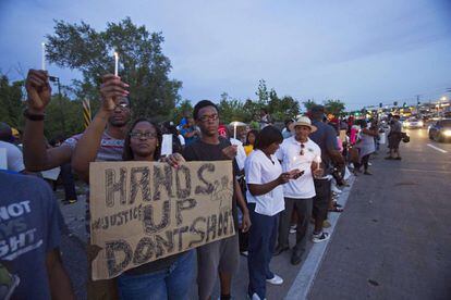 Ciudadanos de Ferguson se manifiestan pacificamente ante la visita del gobernador de Misuri, Jay Nixon.