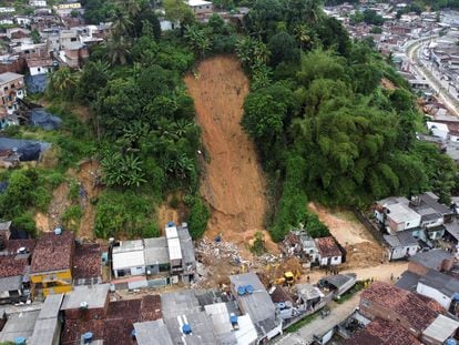 Bomberos, voluntarios y soldados trabajan este domingo en el lugar donde un deslizamiento de tierra de tragó una casa en Recife.