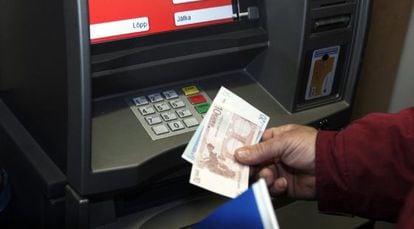 Un hombre retira euros de un cajero automático.
