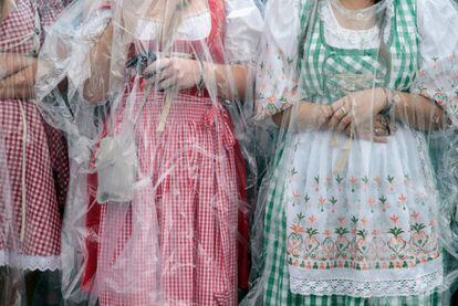 Mujeres con el tradicional traje bávaro se protegen de la lluvia con unos plásticos, el 1 de octubre de 2014.