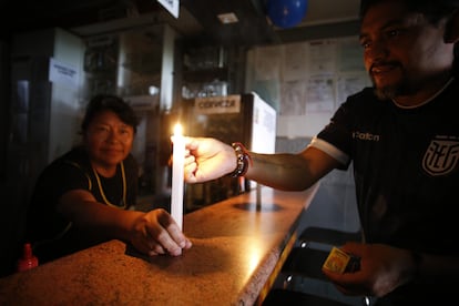 Una pareja enciende velas en Quito, Ecuador. Los ciudadanos están experimentando un malestar por los cortes diarios sectorizados de energía.