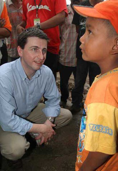 Alexander habla con un niño durante una visita a Aceh, en Indonesia.