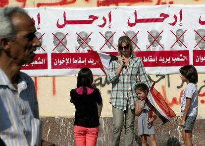 Una mujer y sus hijos posan para una fotografía junto a una pancarta contra la Hermandad Musulmana en el inicio de una protesta para exigir a Morsi que se marche.