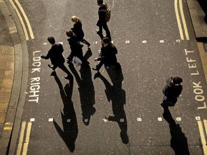 Ejecutivos pasan un paso de cebra en la City de Londres (Reino Unido).