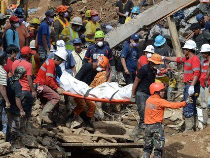 Los equpos de rescate portan el cuerpo de una víctima del desprendimiento de tierra en Itogon.