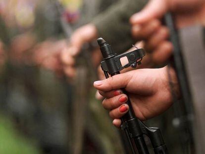 Una guerrillera de las FARC sujeta un fusil.