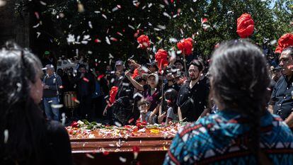 Hijas de Joan Jara realizan un homenaje durante su funeral en la entrada del cementerio general, en Santiago, Chile.