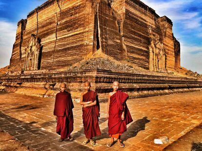 Tres novicios budistas posan ante Mingun Paya, la pagoda inacabada.