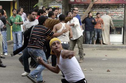 Manifestantes cristianos coptos lanzan piedras contra la policía egipcia durante la protesta en El Cairo.