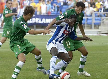 Varela, del Recreativo de Huelva, avanza con el balón marcado por Caffa y Babic