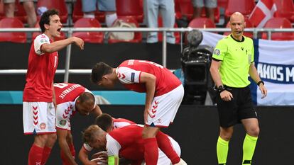 Los jugadores de Dinamarca atienden a Eriksen sobre el césped, el 12 de junio en Copenhague (Dinamarca).