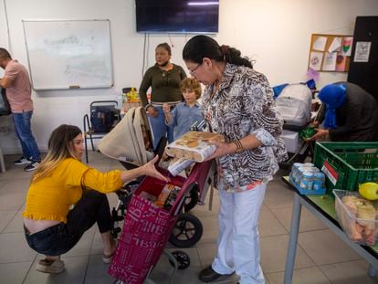 Cony Platero, en el centro, recoge alimentos este miércoles en el local de la ONG Esperanza Latina de San Sebastián.