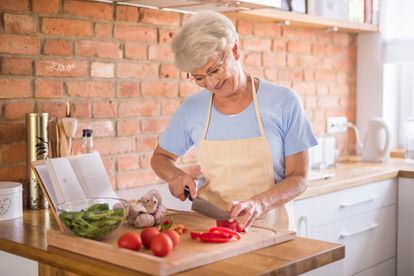 Senior woman cutting vegetables