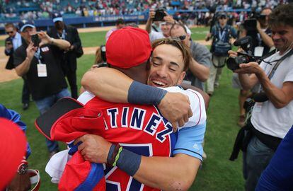Dayron Varona de los Tampa Bay Rays que deserto de Cuba en 2013 se abraza a un jugador de la selección cubana de béisbol después del partido.
