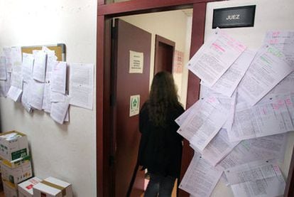 Edictos de subastas de pisos embargados cuelgan de las paredes en un juzgado de Madrid.