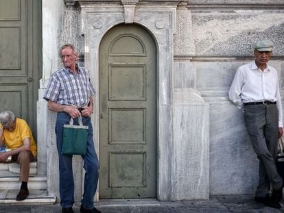 Tres pensionistas aguardan fuera de la sede del Banco Nacional de Grecia, el 9 de julio.