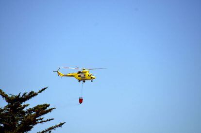 Un helicóptero de las brigadas forestales transporta agua hacia el frente de Nambroque, en La Palma.