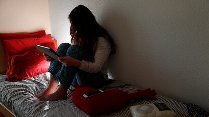 Una adolescente mirando uno de sus aparatos electrónicos.