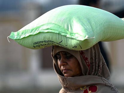 Una mujer llevaba un saco de harina de trigo en Islamabad (Pakistán). El país sufre una fuerte crisis económica y política agravada por las recientes inundaciones.