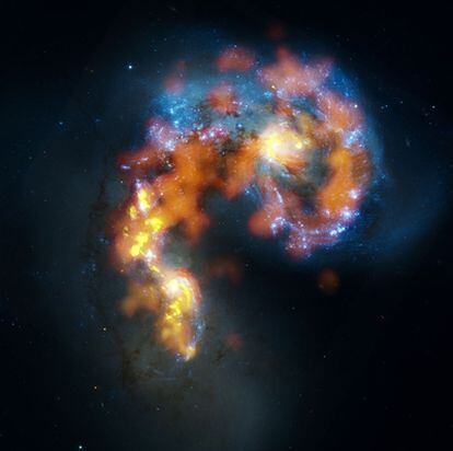 Las dos galaxias de las Antenas, que, al estar en colisión, tienen formas distorsionadas, en una imagen compuesta de las observaciones de ALMA y el <i>Hubble</i>.