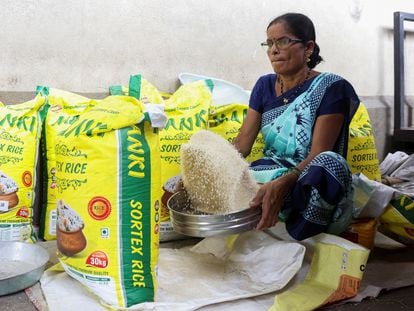 Una mujer limpia granos de arroz en un mercado mayorista de Navi Mumbai, India, en agosto de 2023.