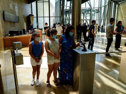 Visitantes usando su móvil a la entrada del museo Guggenheim en Bilbao el 3 de junio.