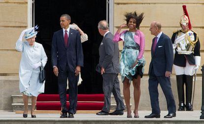 La reina Isabel sujeta su sombrero, durante una recepción al matrimonio Obama en el palacio de Buckingham.