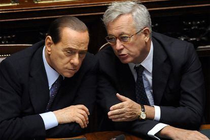 El primer ministro italiano, Silvio Berlusconi, conversa con el ministro  de Economía, Giulio Tremonti, durante la sesión de ayer en el Parlamento italiano
