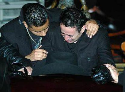 Arriba, dos integrantes del grupo K-Paz ante el féretro de Sergio Gómez (a la izquierda), asesinado el 2 de diciembre al término de un concierto.