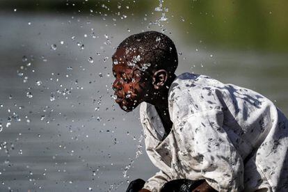 Un niño se salpica con agua en el río Atbarah cerca de la aldea de Dukouli, en la región agrícola de Fashaqa al-Sughra, en el este de Sudán, el 16 de marzo de 2021.