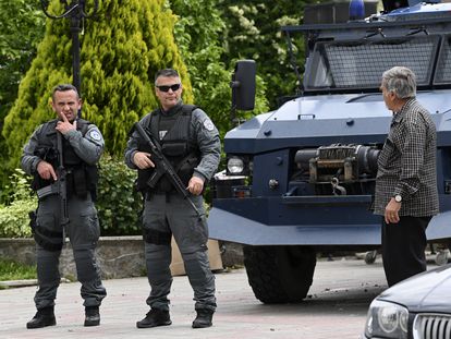 Policías kosovares que custodian el edificio municipal de Leposavic, localidad de la zona mayoritariamente serbia, hablan con un vecino, este sábado.