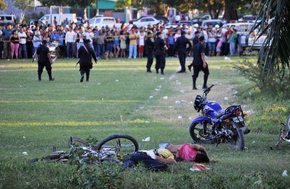 La policía acordona la zona donde se encuentran los cadáveres de los hombres asesinados en un campo de fútbol en Honduras.