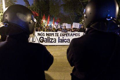 La Polícia Nacional contra la marcha en Santiago de Compostela contra la visita del Papa a la capital gallega. En la pancarta: "No te esperamos. Galicia laica".