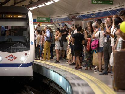 Un tren llega al andén repleto de viajeros de la estación de metro de Sol.
