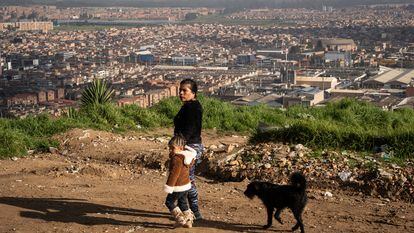 Una mujer camina con su nieta en un barrio con alto índice de pobreza en Colombia.