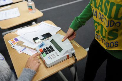 No hombre marca su voto su huella digital en la marcadora digital en una casilla electoral de São Paulo. 
