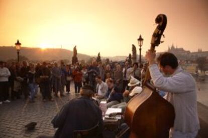 Músicos callejeros tocando junto al puente Carlos, en Praga.