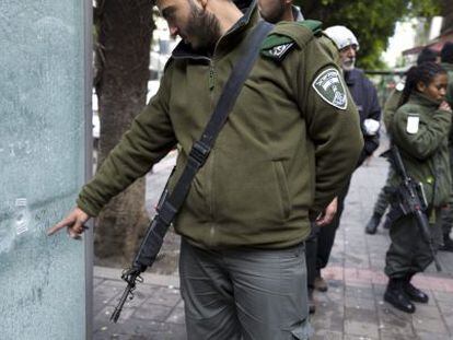 Un polic&iacute;a israel&iacute; apunta al impacto de una de las balas disparadas contra los clientes del bar de Tel Aviv.