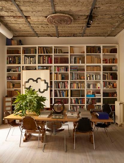 La biblioteca está surtida por igual de libros heredados, novedades editoriales y un gran chillida. Delante, una mesa diseñada por Albistur y rodeada de sillas de Perriand. Las sillas de rejilla metálica las compraron al Centro Pompidou cuando el museo fue reformado.