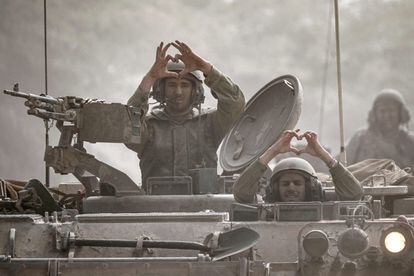 Soldados israelíes hacen gestos desde uno de los tanques establecidos en la frontera con Gaza, este viernes.