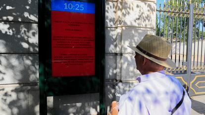 Un hombre lee un aviso que informa del cierre del parque de El Retiro, en Madrid, el pasado domingo 31 de julio.