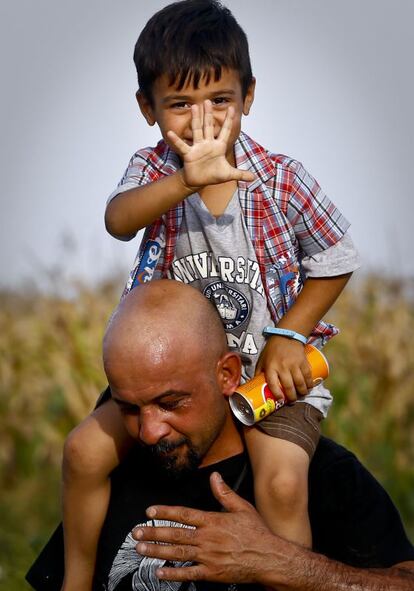 Un niño a hombros de su padre en la frontera serbo-croata.