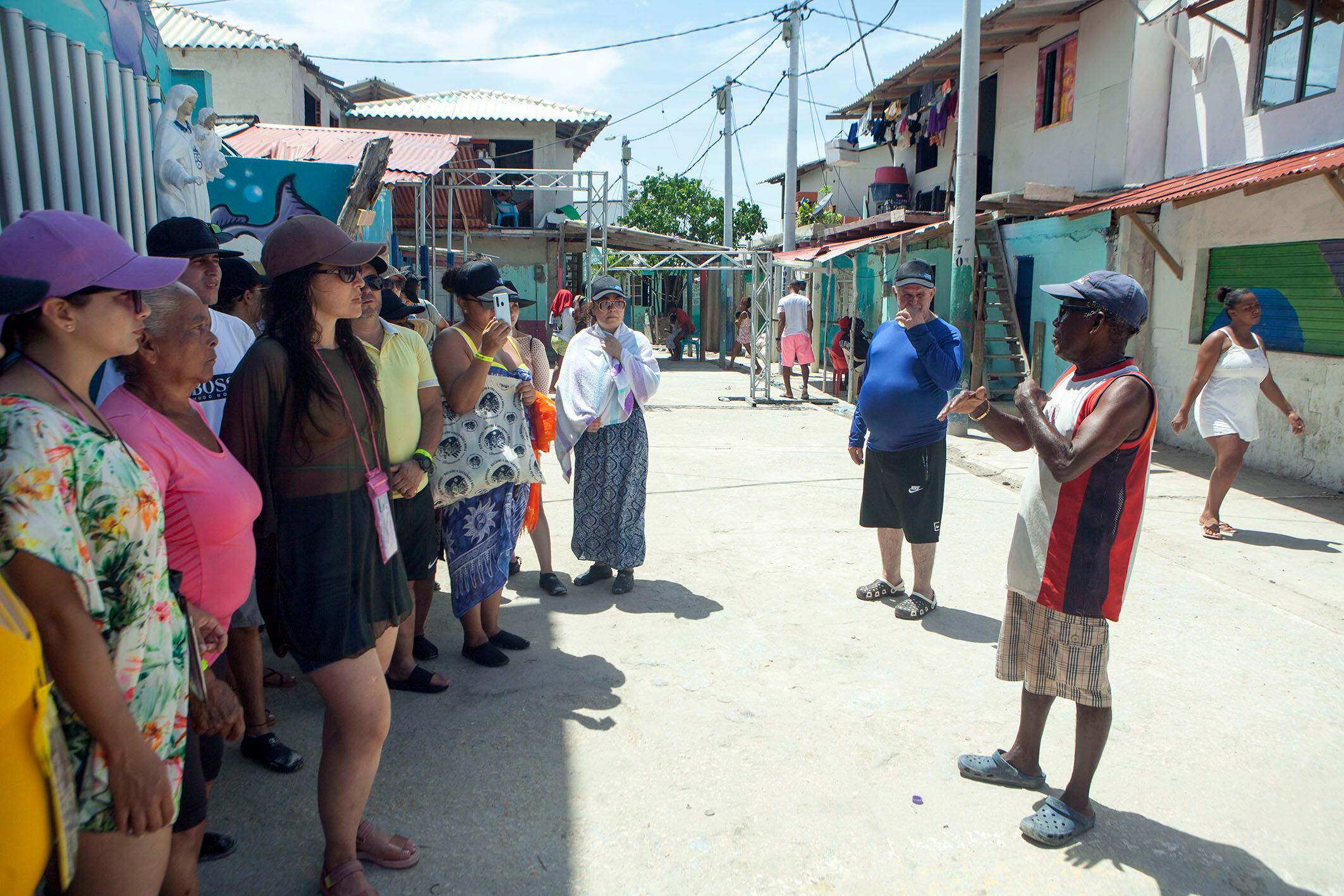 A tour guide explains interesting facts about Santa Cruz del Islote to a group of visitors.