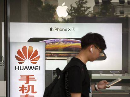 Un hombre consulta su teléfono ante una tienda de Apple en Pekín. 