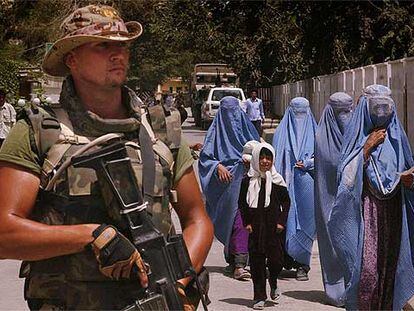 Un soldado español, junto a un grupo de mujeres afganas ataviadas con <i>burka,</i> en Kabul en julio de 2004.